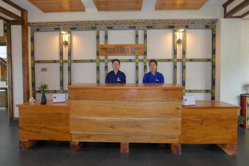 two women standing behind the counter of a restaurant at Willing Resort, Trongsa in Kagha