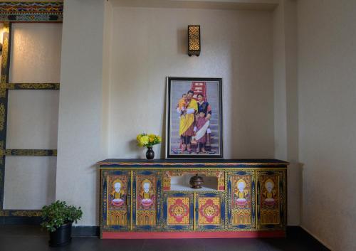 a colorful cabinet in a room with a picture on the wall at Willing Resort, Trongsa in Kagha