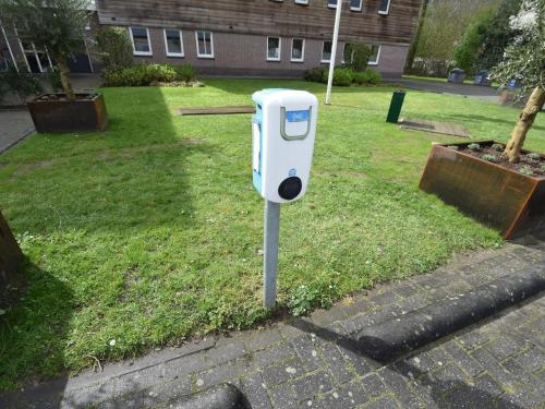 a parking meter on the grass in a yard at Holiday home for group with sauna and pool in Havelte