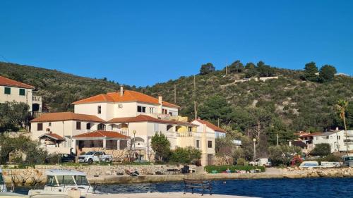 a group of houses on the shore of a body of water at Apartment Zaglav 3 - first sea row in Zaglav