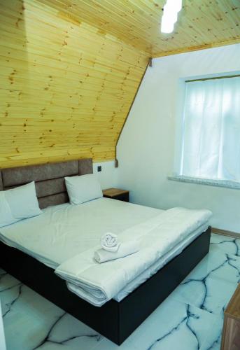 a large bed in a room with a wooden ceiling at A-Frame Villa in Gabala with Garden & FREE Airport shuttle in Gabala