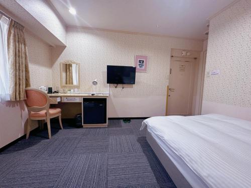 a hotel room with a bed and a desk at Nissei Hotel Fukuoka in Fukuoka