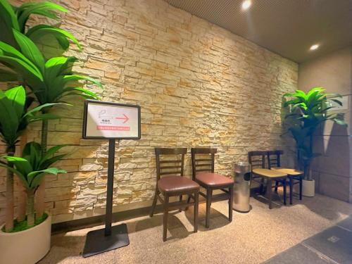 a waiting room with chairs and a stone wall at Nissei Hotel Fukuoka in Fukuoka