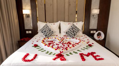 a heart made out of flowers on a bed at Milan Park Hotel in Taif