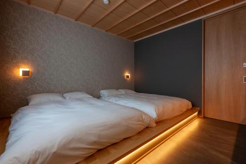 a bedroom with two large white beds in it at DA TATEYAMA con amore in Tateyama