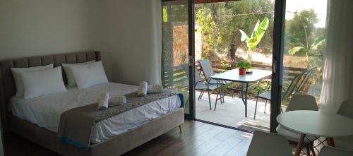 a bedroom with a bed and a balcony with a table at Mediterranean Studio Ratzakli in Ratzaklíon