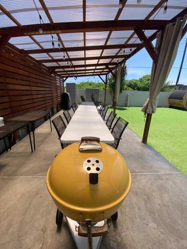 a yellow table and chairs under a roof at 海まで徒歩5分-BBQ バレルサウナ ジャグジー ペットOKの貸切villa in Ichinomiya
