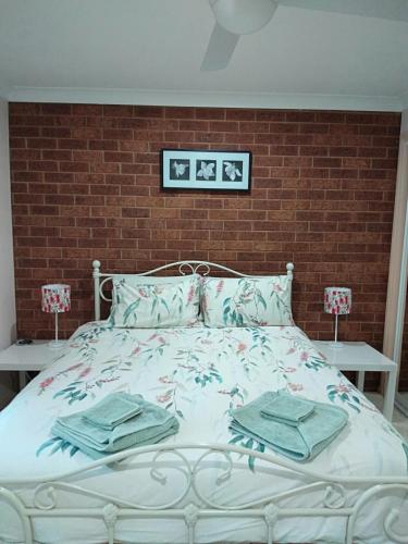 a bedroom with a bed with towels on it at The Bottlebrush in Tumut
