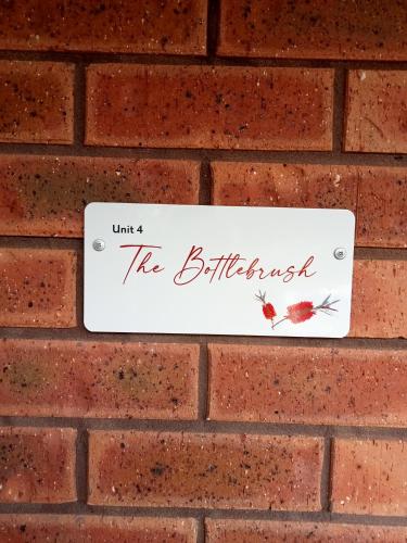 a sign on a brick wall that reads the birthday at The Bottlebrush in Tumut