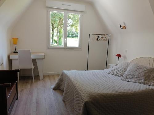 une chambre avec un lit, un bureau et une fenêtre dans l'établissement Chambre d'hôtes Ste Marie, à Sainte-Marie