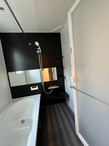 a bathroom with a white tub and a sink at 海まで徒歩5分-BBQ バレルサウナ ジャグジー ペットOKの貸切villa in Ichinomiya