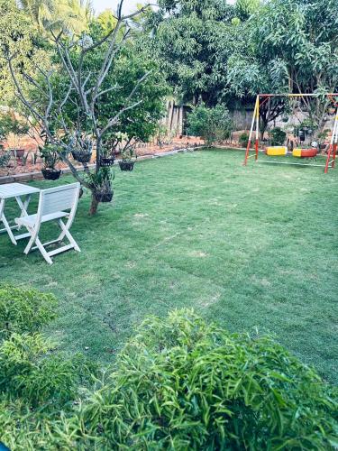 a white bench sitting in the middle of a yard at Muine Sports Hotel in Mui Ne
