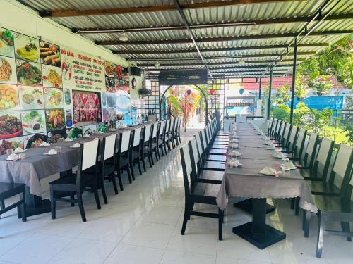 a long row of tables and chairs in a restaurant at Muine Sports Hotel in Mui Ne