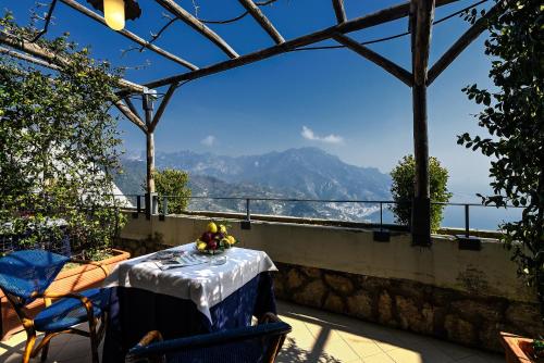 a table on a balcony with a view of the mountains at Hotel Graal in Ravello