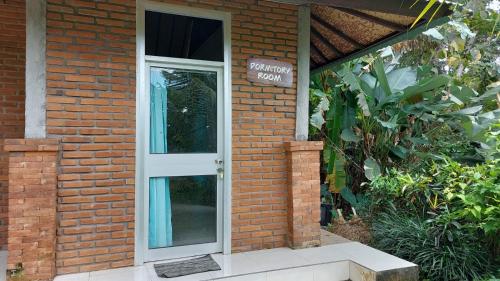 a brick house with a white door on it at Arnata Guest House & Pasraman Yoga Lokanata in Bangli