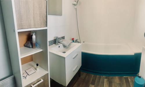 La salle de bains est pourvue d'un lavabo et d'une baignoire. dans l'établissement Maison 2 chambres- grand jardin-WIFI - au cœur du village AUBETERRE -visites- conciergerie J&N, à Aubeterre-sur-Dronne