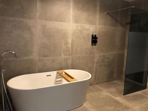 une baignoire dans une salle de bain avec douche dans l'établissement La Maison de la Mare, à Prenois