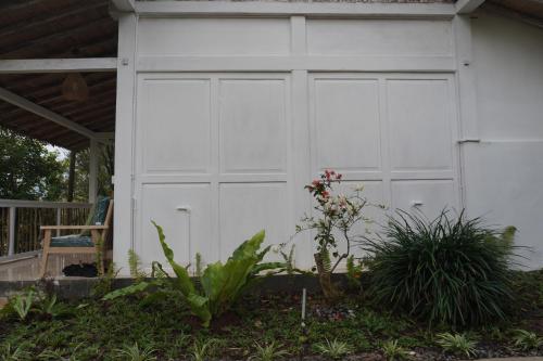 a white garage door on the side of a house at Purwa Ijen in Banyuwangi