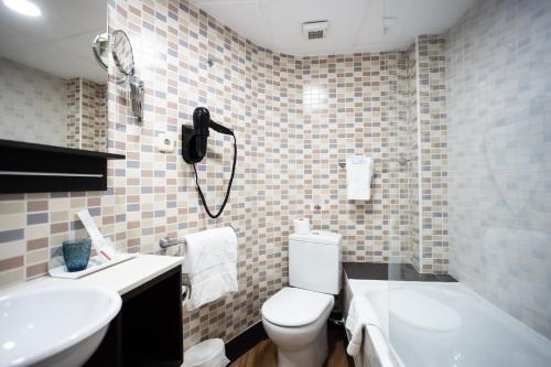 a bathroom with a toilet and a sink and a phone at Venecia Plaza Centro in Valencia