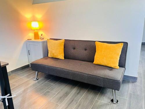 a couch with two yellow pillows in a room at Super Loft ubicadísimo cerca Visas Hospital in Heroica Nogales