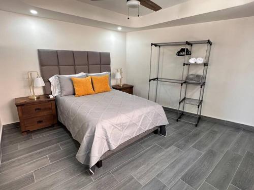 a bedroom with a bed with orange pillows and a shelf at Super Loft ubicadísimo cerca Visas Hospital in Heroica Nogales