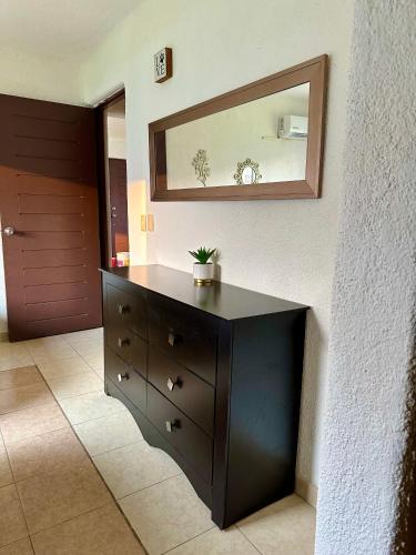 a black dresser in a room with a mirror at Departamento en Pb frente a la alberca in Acapulco