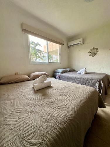 a bedroom with two beds and a window at Departamento en Pb frente a la alberca in Acapulco