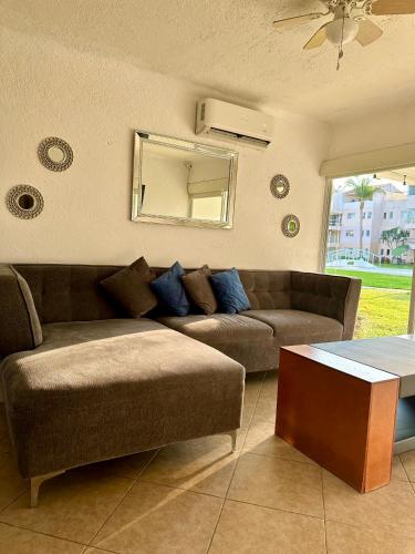 a living room with a couch and a mirror at Departamento en Pb frente a la alberca in Acapulco