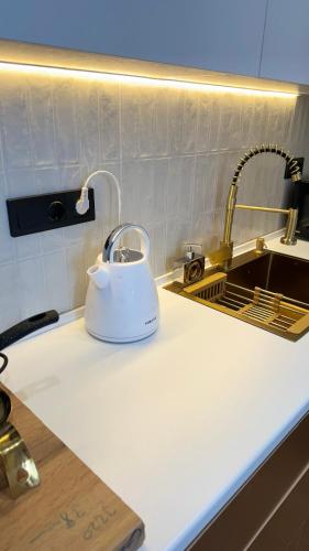 a white tea kettle sitting on a kitchen counter at Apartament sunny Kobuleti in K'obulet'i