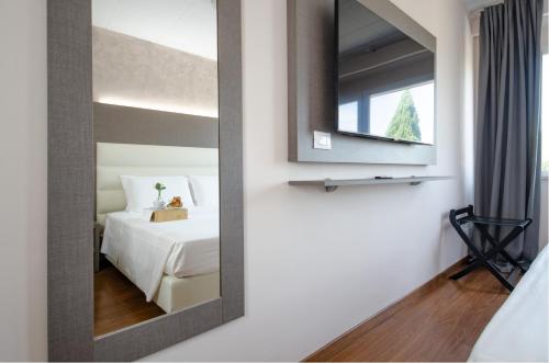 a mirror in a hotel room with a bed at Hotel Palace del Conero in Osimo