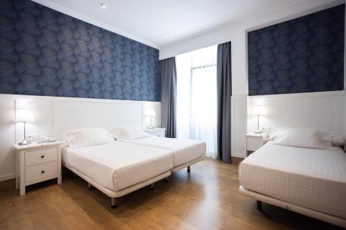 a bedroom with two beds and a window at Venecia Plaza Centro in Valencia