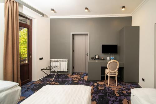a bedroom with a bed and a desk with a computer at Kefilyan Family Hotel in Haghpat