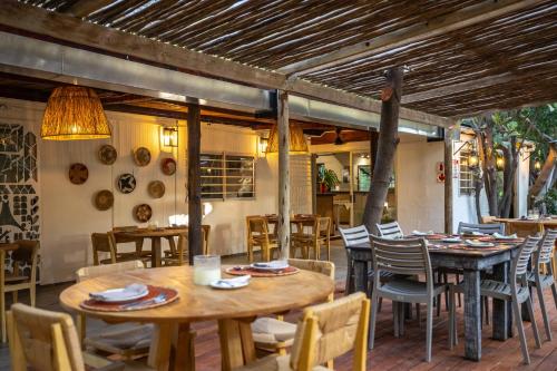 a restaurant with wooden tables and chairs and a table and chairs at The Waterfront, Maun in Maun