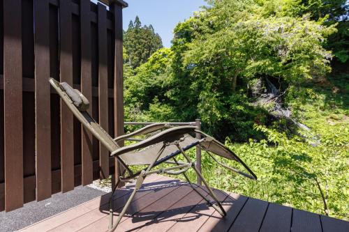 a metal chair sitting on a porch at Fujisan Ryokan in Hanamaki