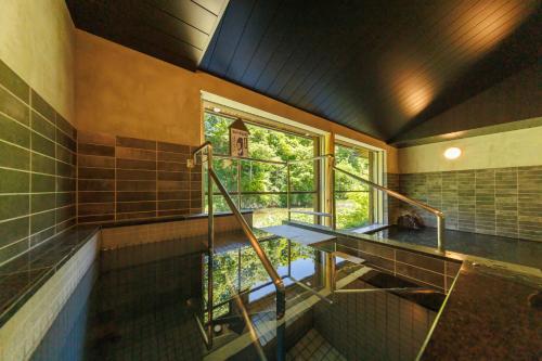 a bathroom with a glass staircase and a window at Namari Onsen Kokoro No Toki Jusangatsu in Hanamaki