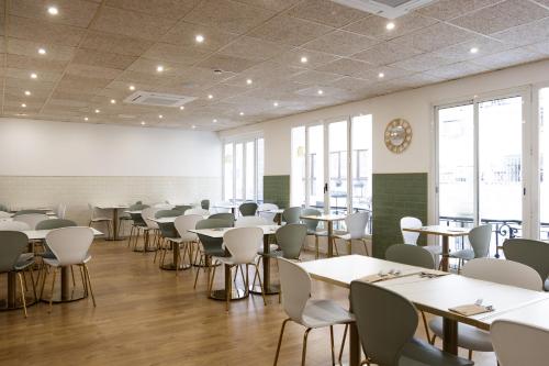 a dining room with tables and chairs and windows at Venecia Plaza Centro in Valencia