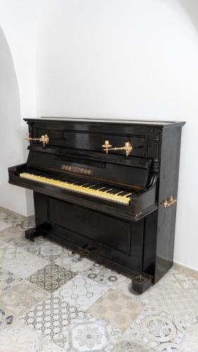 a black piano sitting on top of a floor at Badde Amena Affittacamere in Suni