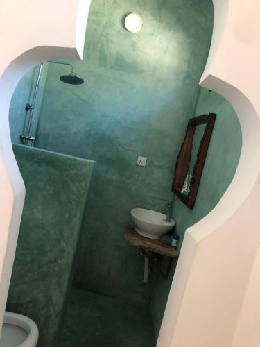 a bathroom with a sink and a mirror at Gecko House in Jambiani