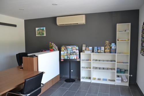 a waiting room with a counter and a table and shelves at Camping Parc Valrose in La Londe-les-Maures