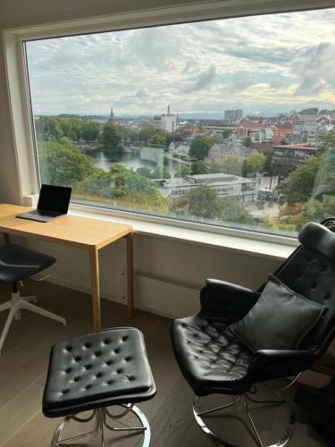 a room with a desk and chairs and a large window at ONS 2024, sentrum Stavanger in Stavanger
