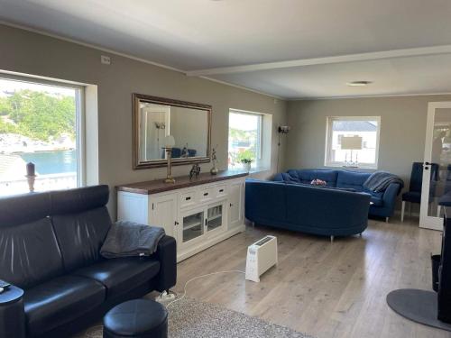 a living room with two blue couches and a mirror at 6 person holiday home in BØMLO in Bømlo