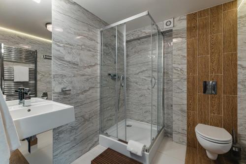 a bathroom with a shower and a toilet and a sink at Rewita Rynia in Białobrzegi