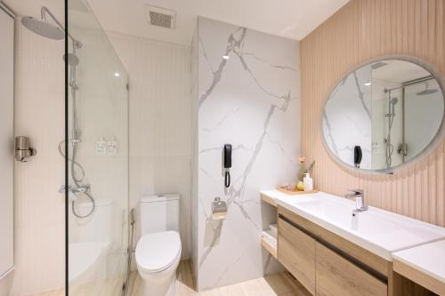a bathroom with a shower and a toilet and a sink at Centara Life Lamai Resort Samui in Lamai
