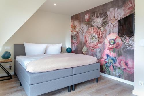 a bedroom with a bed with a floral wall at Family Hüs in Westerland (Sylt)