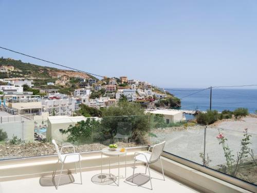 a balcony with chairs and a view of the ocean at Golden Luxury Suites in Balíon