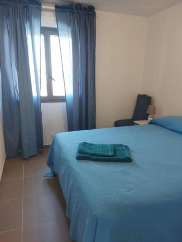 une chambre avec un lit bleu et une fenêtre dans l'établissement Maison vacances, à Aigues-Mortes