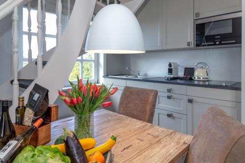 a kitchen with a table with a vase of flowers at Leo in Keitum