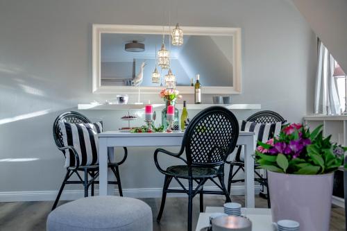a dining room with a white table and chairs at KleinKeitum in Keitum