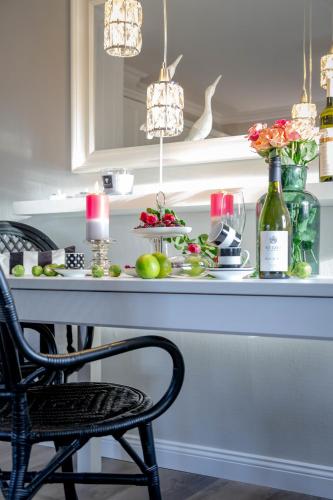 a dining room table with fruit and wine bottles at KleinKeitum in Keitum