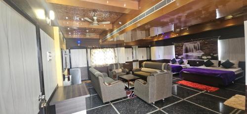a living room with couches and a couch at Anyhour Stay in Gannavaram